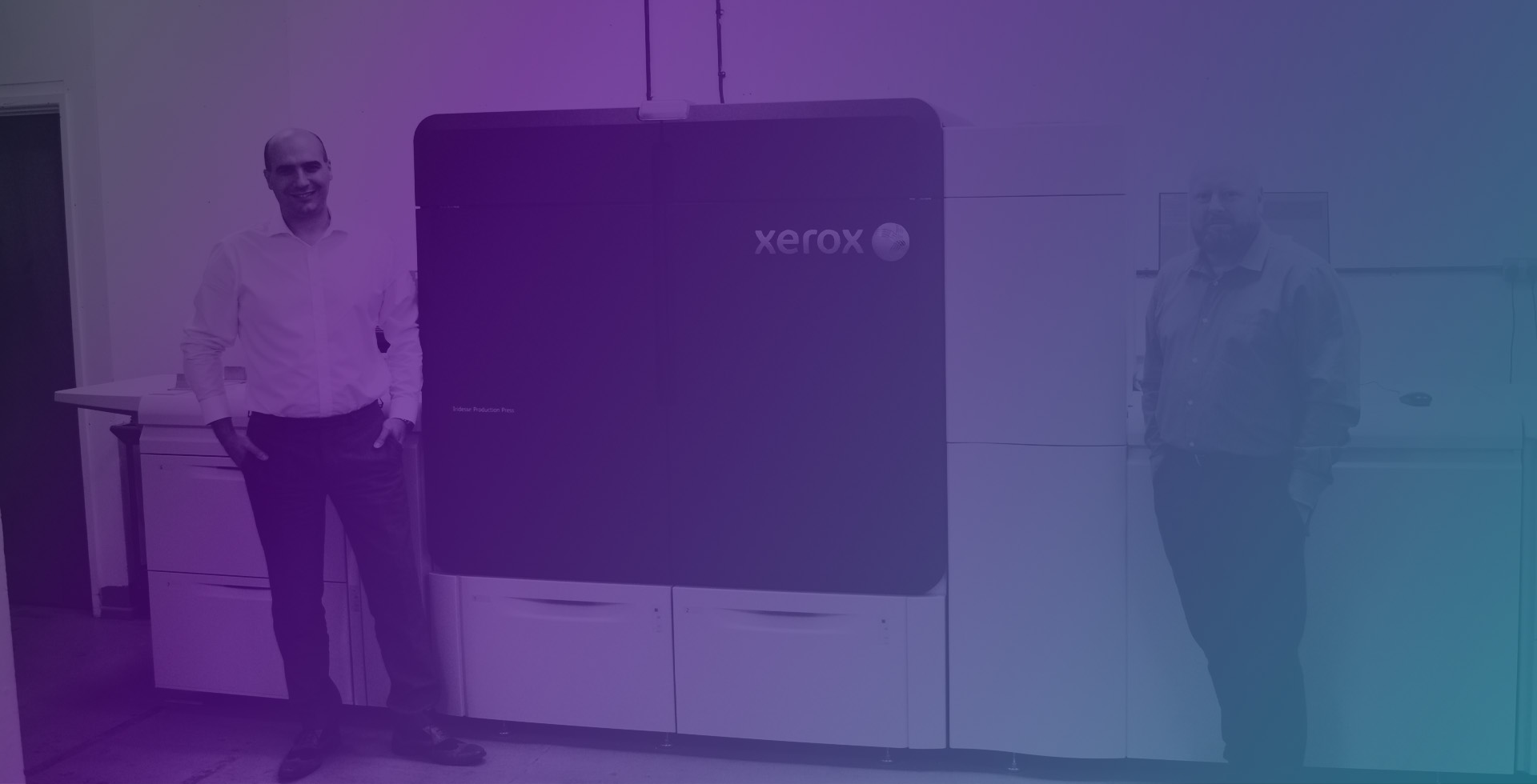 Two colleagues standing in front of Xerox printer
