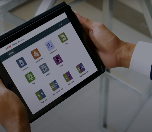 Man holding a tablet looking at Xerox Workflow Central Icons