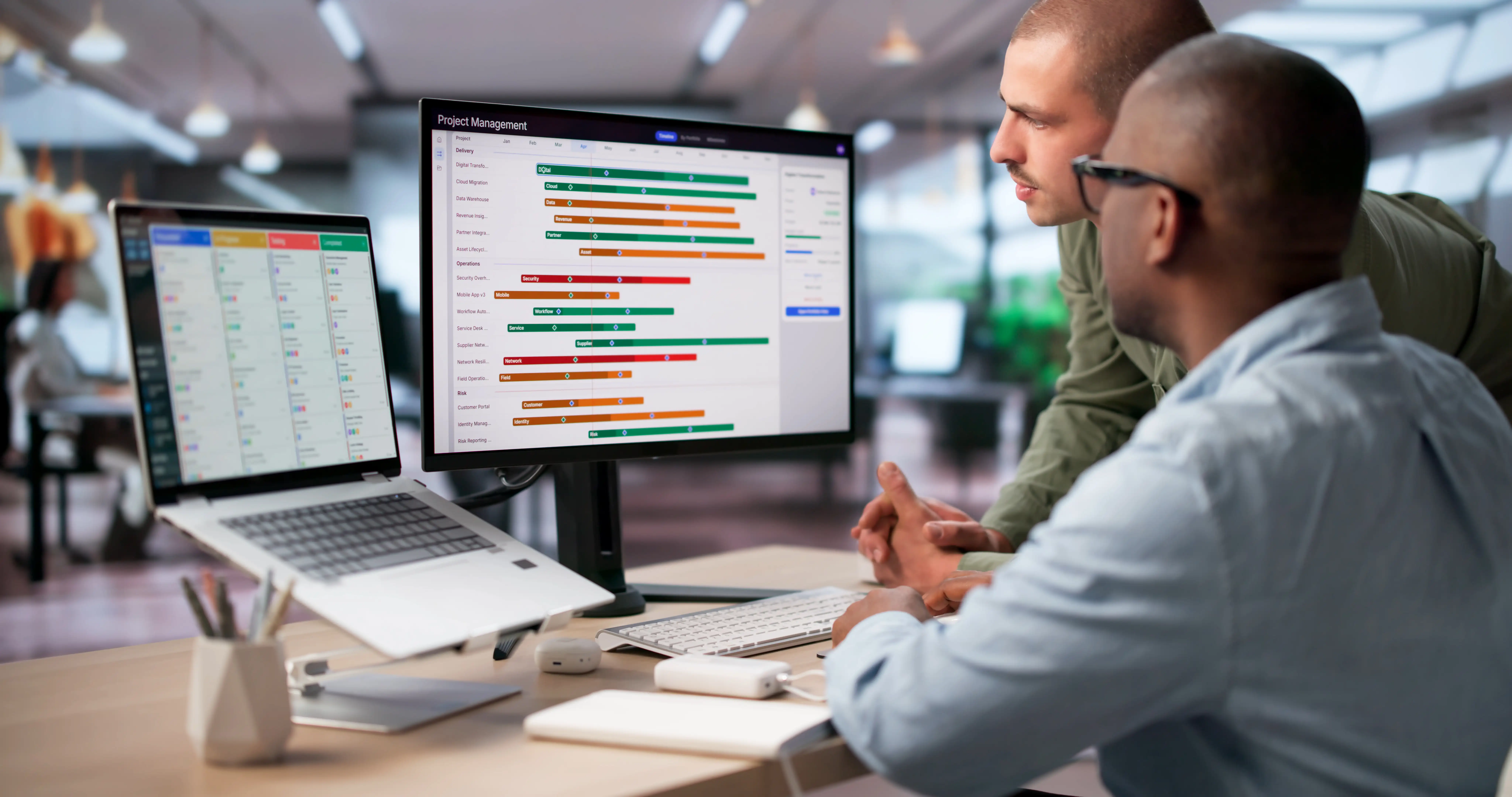 Two men looking a some PC screens in an office