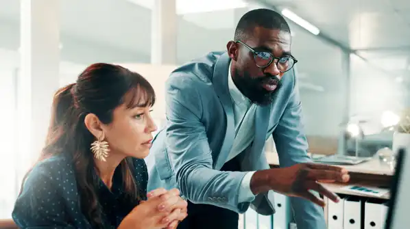 Colleagues looking at a computer screen in an office