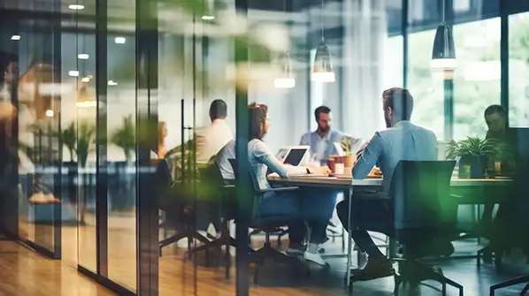 Office workers sitting around table working